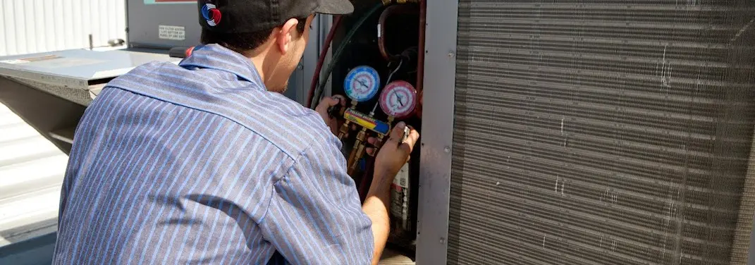 HVAC technician servicing a condenser unit in Scotia