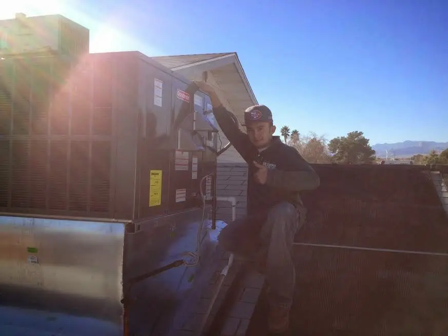 HVAC technician performing HVAC Inspection on a rooftop unit in Scotia